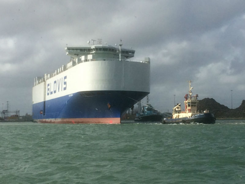 Image of large cargo vessel with tug attached