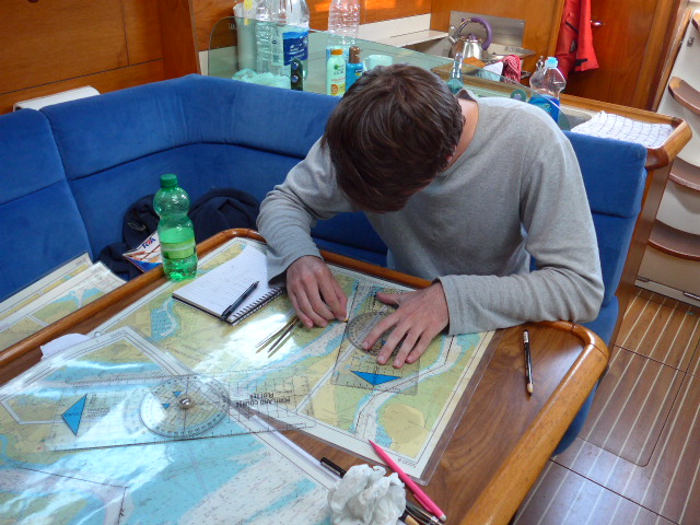 Image of day skipper student planning on the boat using charts